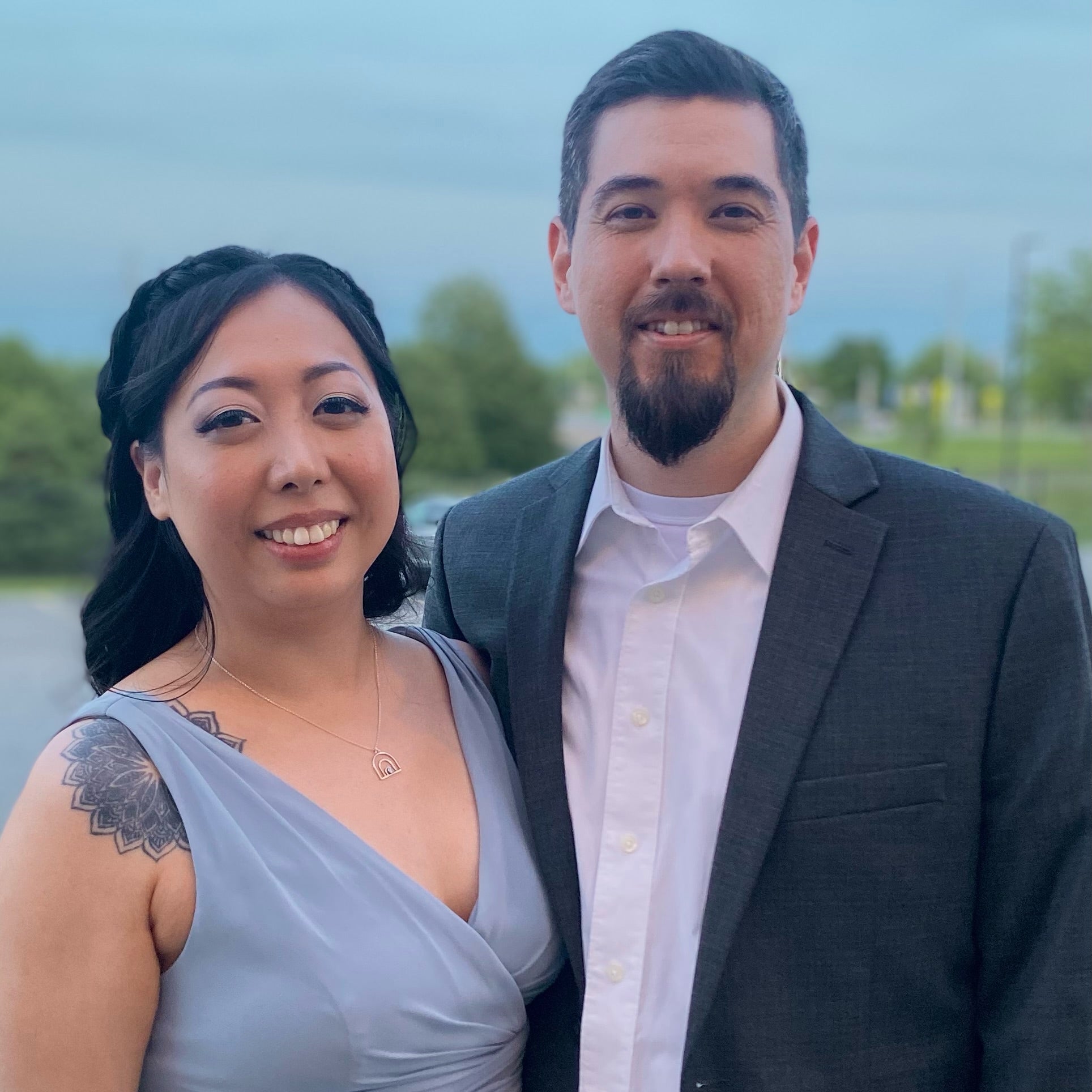 The co-founders, a woman and a man, Nhi Kha and John Frazier, posing together outdoors with a blurred background